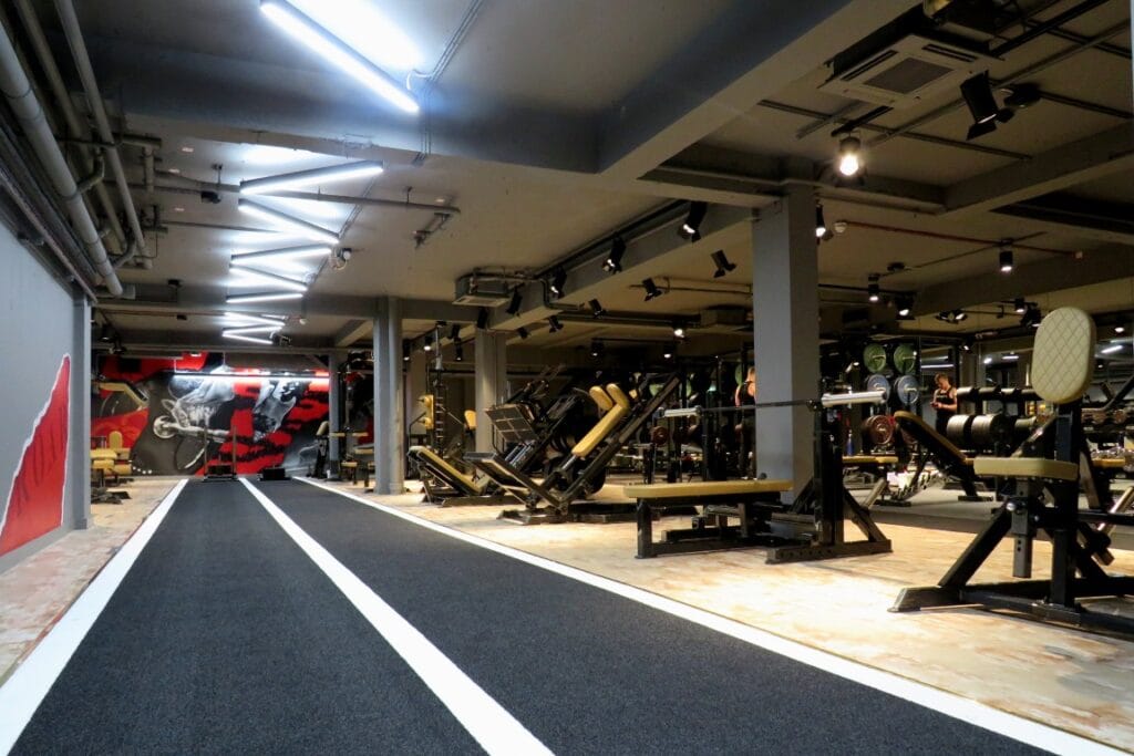 Luxurious gym interior with 25-meter track and advanced strength training equipment at Roar Fitness Kensington.